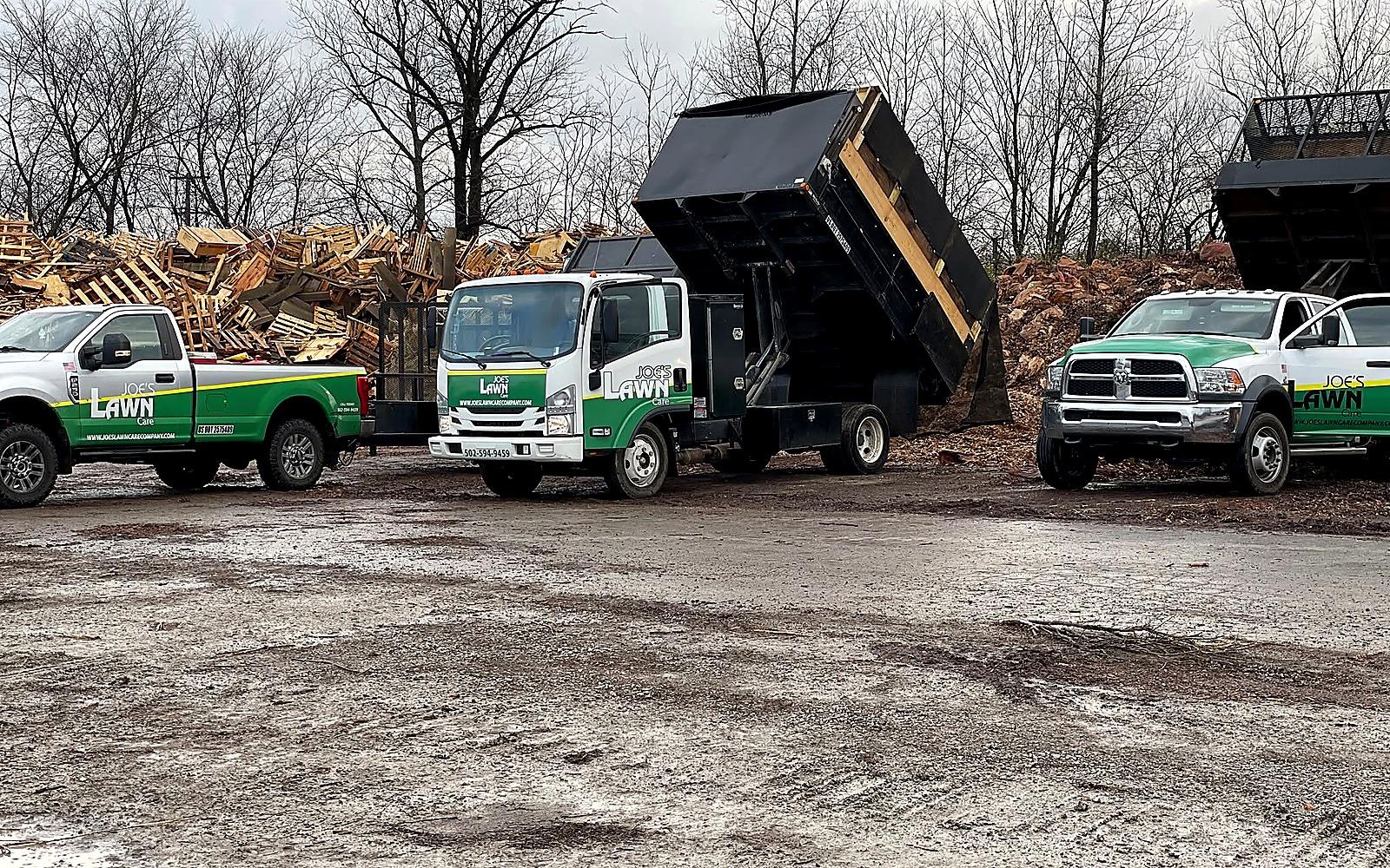 Joe's Lawn Care dump trucks and outdoor project equipment